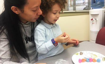 A mother and son making a toy caterpillar.