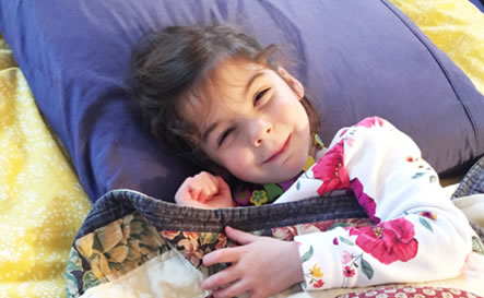 A girl lying down on a pillow.