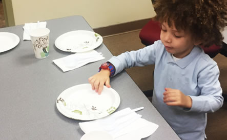 A boy setting the table.